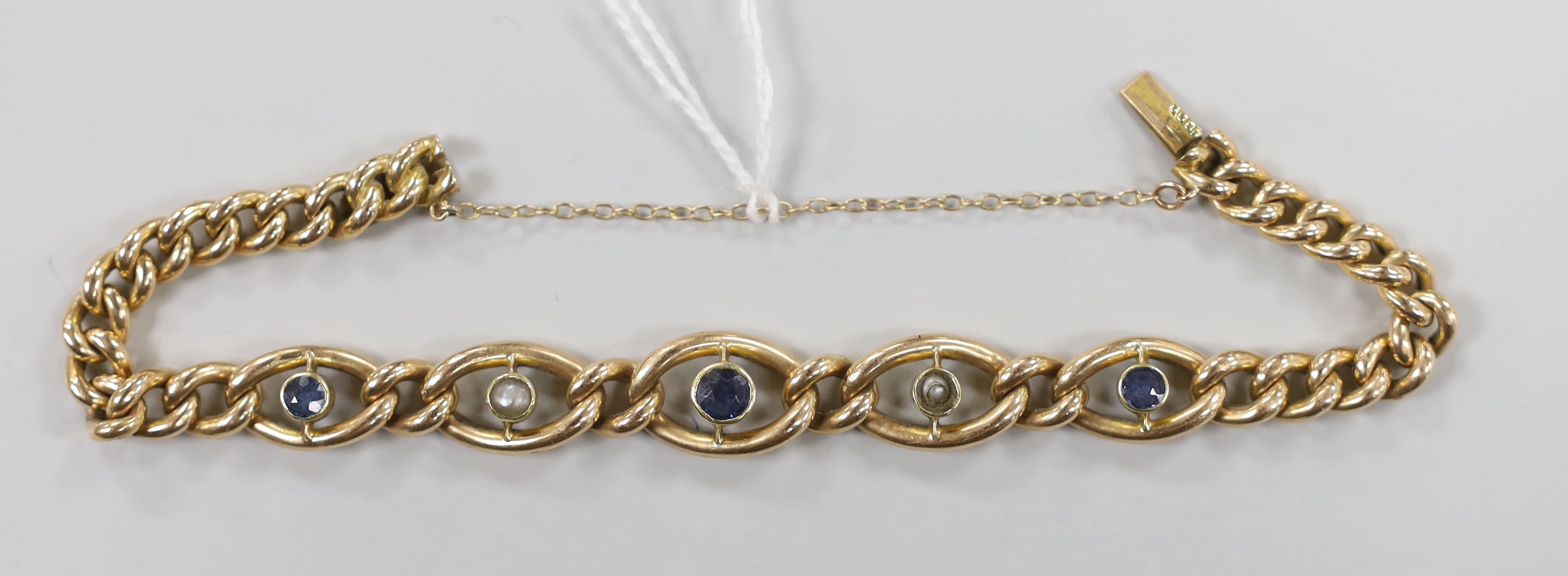 An Edwardian 15ct, sapphire and seed pearl set curb link bracelet, approx. 18cm